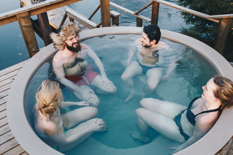 Quatre amis qui se détendent dans un spa extérieur